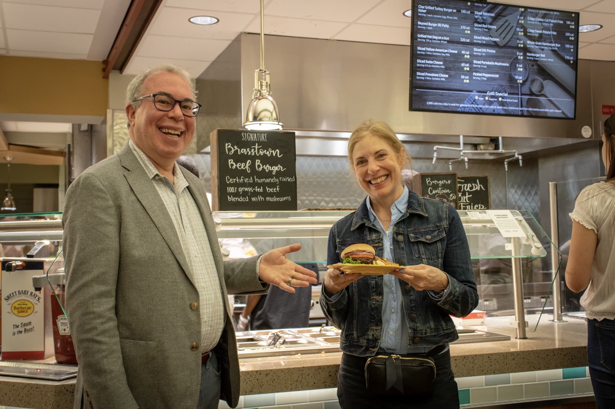 man and woman showing off burger