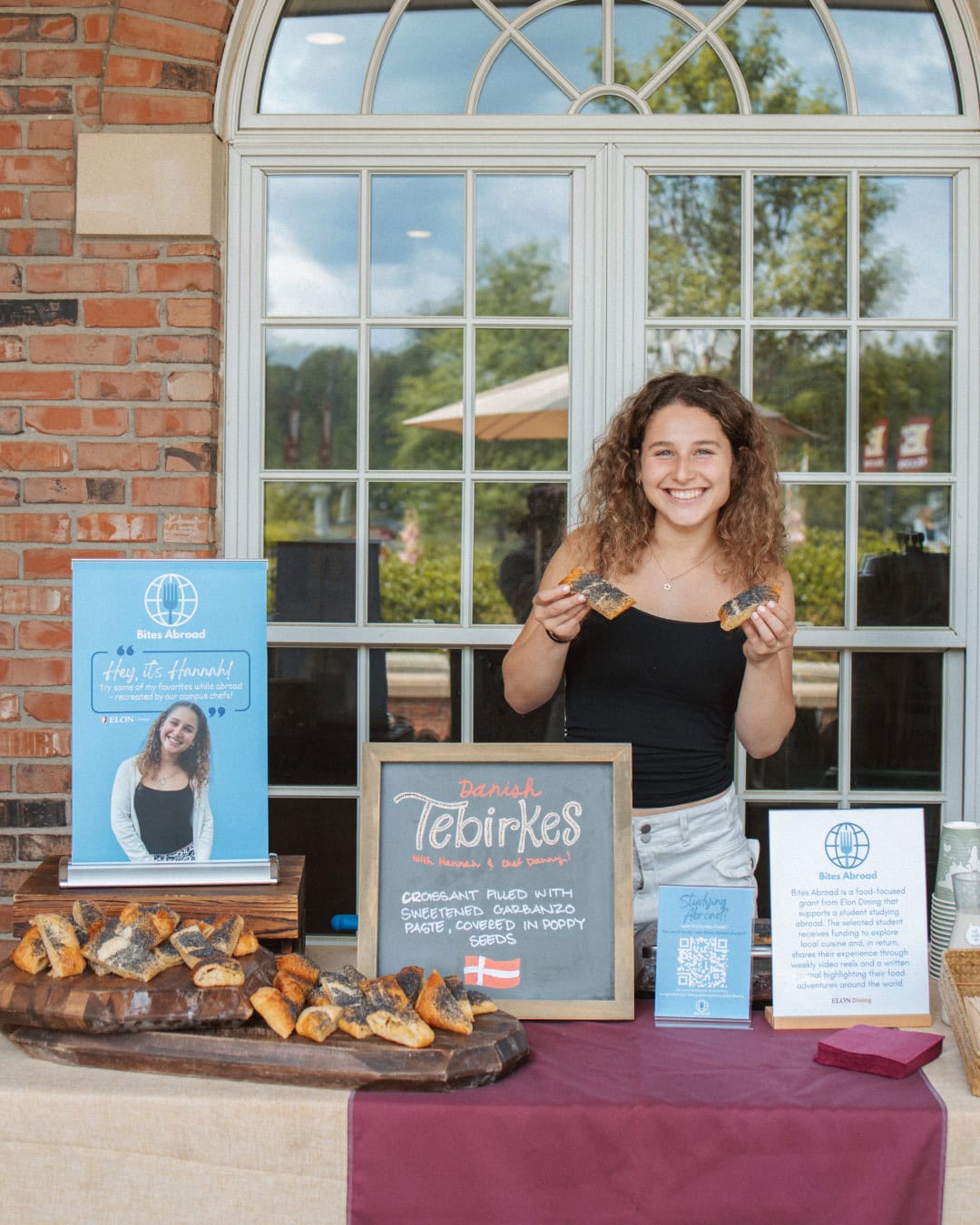 Hannah stands behind table with free samples